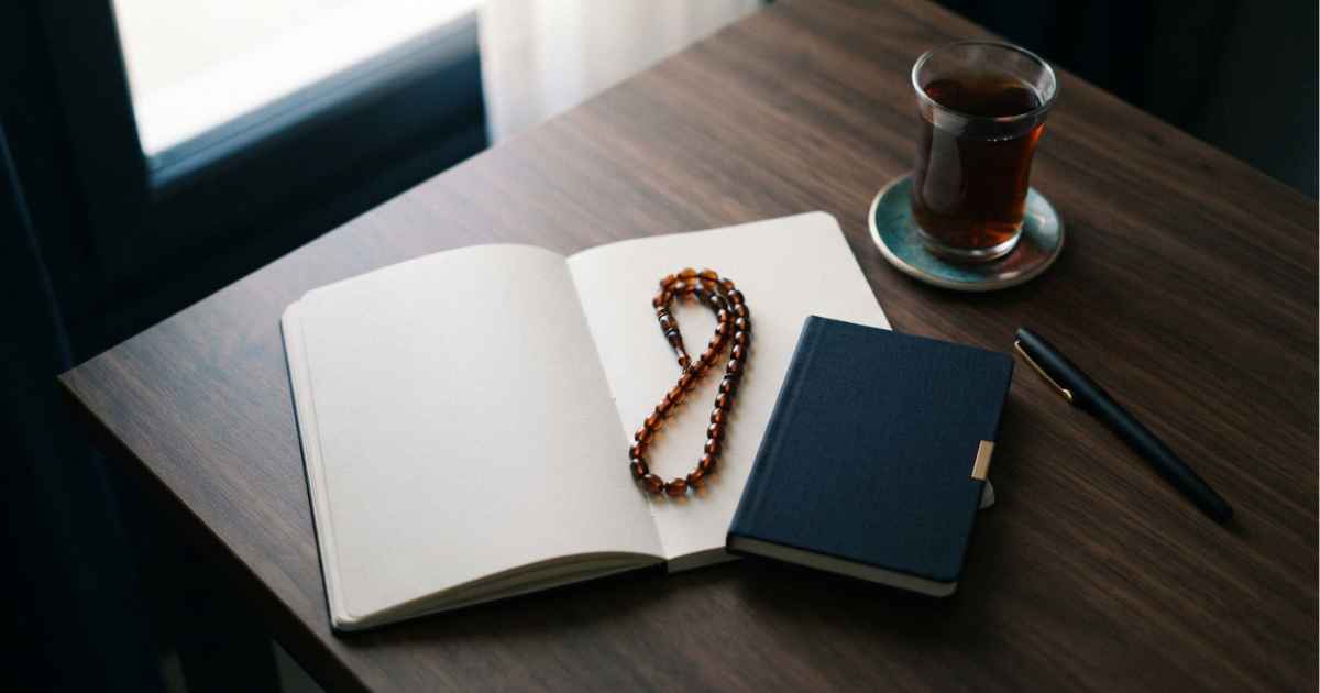 دفتر برنامه‌ریزی مالی در کنار تسبیح؛ نمادی از همراهی نیایش با اقدام عملی